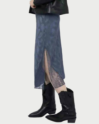 A person in a Zadig & Voltaire Jayla Paisley Skirt with a blue paisley pattern and front slit, paired with a black jacket and black cowboy boots, stands against a plain background.
