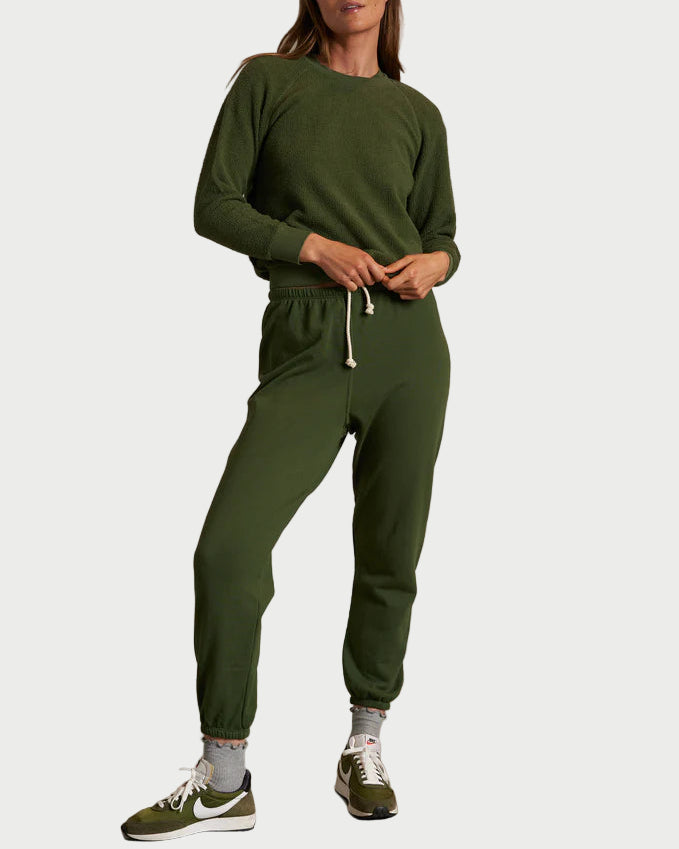 Person wearing a green tracksuit against a plain background