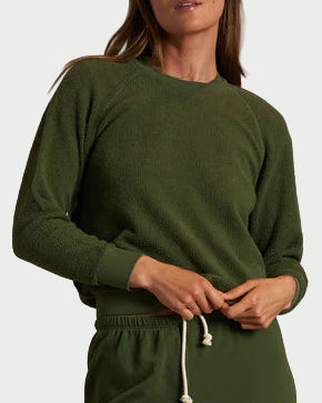 Person wearing a green tracksuit against a plain background