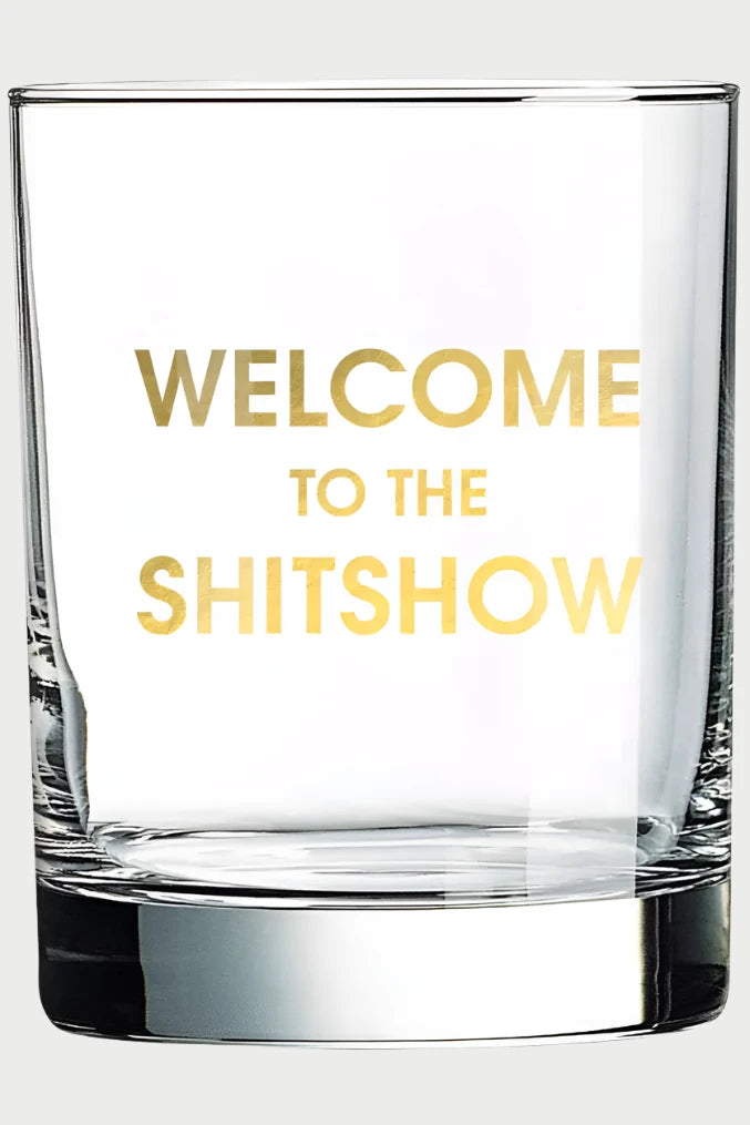 Ideal for cocktail enthusiasts with a sense of humor, the Chez Gagné Rocks Glass sports "WELCOME TO THE SHITSHOW" in gold foil on clear glass, adding a witty touch to any collection.